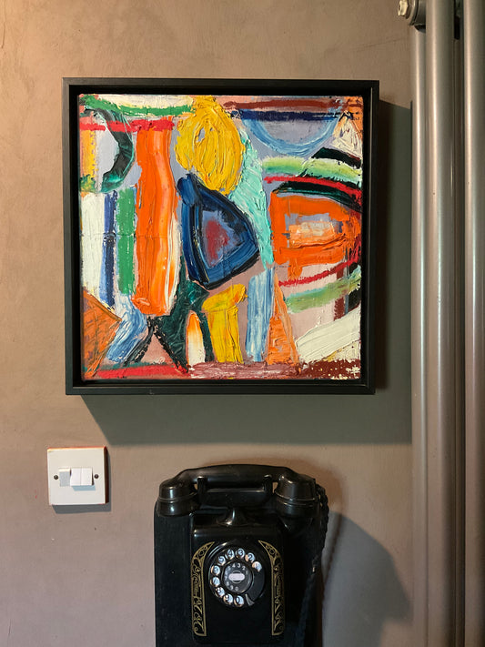 Colorful abstract painting on a wall next to a vintage black rotary phone.